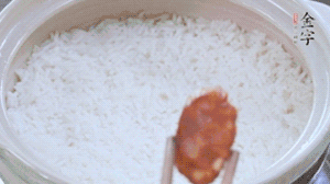 煮開后轉(zhuǎn)小火，當(dāng)米飯出現(xiàn)小孔時(shí)，鋪上金字麻辣香腸。